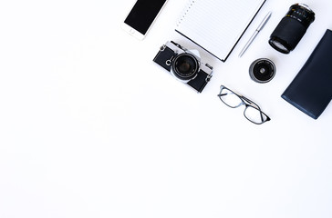 Creative flat lay photo of plain white desk with old camera, note book, pen glasses, sticky, Top view with copy space