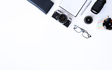 Creative flat lay photo of plain white desk with old camera, note book, pen glasses, sticky, Top view with copy space