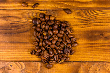 Pile of the coffee beans on wooden table. Top view