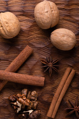 Walnuts, cinnamon and star anise on wooden cutting board. Nuts and spices on the table. Food composition.