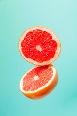 Fresh grapefruit on pastel background. Red citrus fruit sliced in half.	