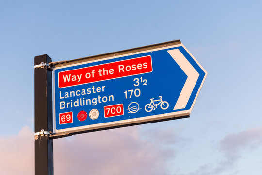 Signpost for the start of the Way of the Roses Coast to Coast cycle route in Morecambe