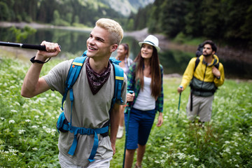 Naklejka premium Group of happy young people friends hiking together outdoor