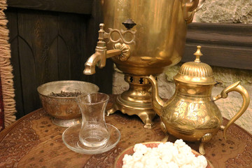 Vintage copper samovar,  glass (armudu), kettle, bowl and sugar (nogul) on the table. Retro background