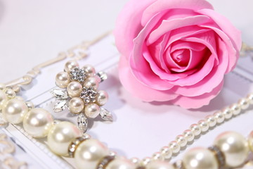 Obraz na płótnie Canvas 薔薇の花と真珠のアクセサリー(ネックレスとブローチ)