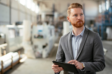 Fototapeta premium Factory supervisor on duty. Inspector comes to a factory Manager at a factory. Boss checking the warehouse during the day