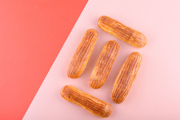 Tasty and beautiful eclairs on a colored background. Delicious dessert