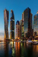 Fototapeta na wymiar Dubai marina modern skyscrapers and luxury yachts at blue hour