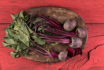 fresh beets with green leaves on a kitchen wooden board