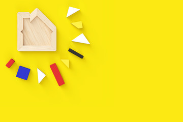 House-shaped puzzle with all pieces removed. In the upper left corner of horizontal format. Yellow background with copy space, flat layout.