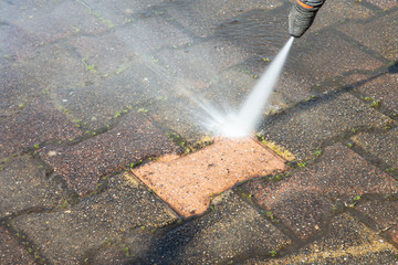 High pressure deep worker cleaning driveway with washer professional services