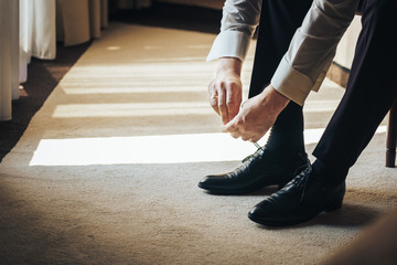 groom tying shoes