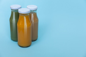 Fresh and healthy avocado and orange juice in bottles isolated on a white background, top view with copy space