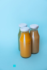 Fresh and healthy avocado and orange juice in bottles isolated on a white background, top view.