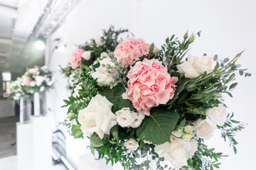 The table of the newlyweds. Small flower arrangements in ball glass vases. Interior of restaurant for wedding dinner, ready for guests. Catering concept.