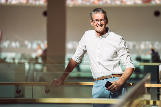 Portrait Of Senior In Modern Bright Business Center Interior