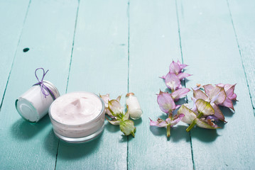 cosmetic creams and clary flowers on blue wooden table