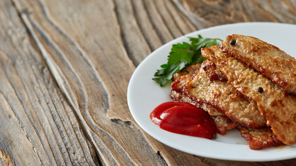 roast meat in a plate on a wooden table. with free text space