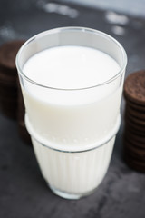 Glass of cold milk and chocolate cookies on the rustic background. Selective focus. Shallow depth of field. 