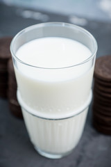 Glass of cold milk and chocolate cookies on the rustic background. Selective focus. Shallow depth of field. 