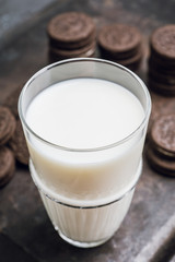 Glass of cold milk and chocolate cookies on the rustic background. Selective focus. Shallow depth of field. 