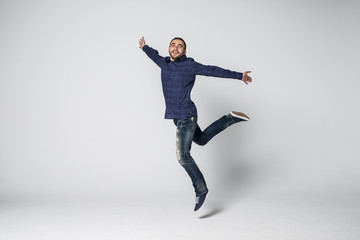 Fototapeta na wymiar Happy excited cheerful young man jumping and celebrating success isolated on a white background