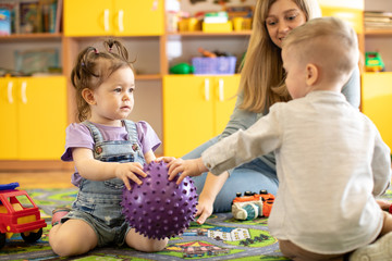 Kindergarten children vie with each other for toy ball.