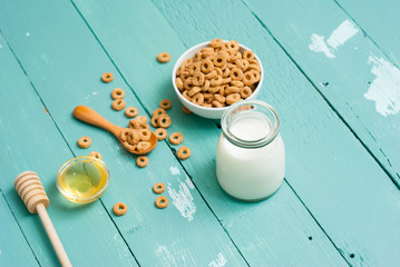 breakfast cereal with milk, honey on blue wood table
