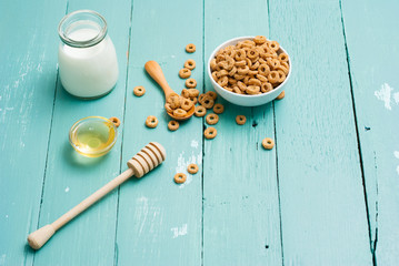 Fototapeta premium breakfast cereal with milk, honey on blue wood table