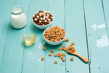 breakfast cereal with milk, honey on blue wood table