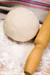 fresh raw dough and rolling pin
