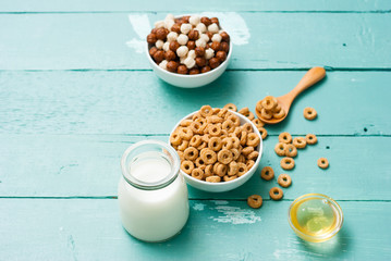 breakfast cereal with milk, honey on blue wood table