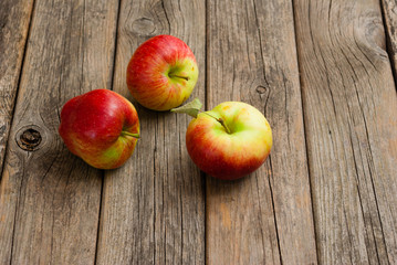 three apples on old wooden background