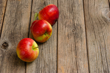 three apples on old wooden background