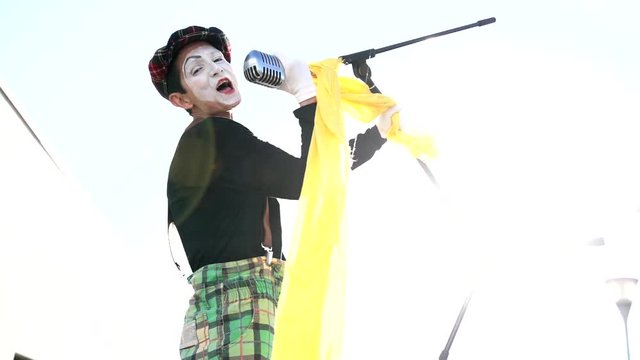 Mime on the street singing with microphone