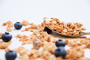 Crispy muesli and blueberry on a spoon Breakfast cereal isolated on white background, selective focus, top view