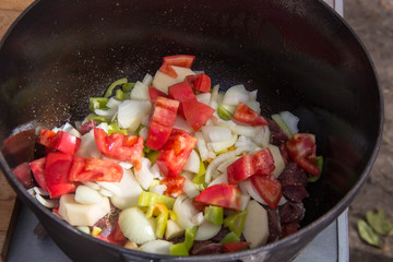 Metal stock pot with soup ingredients vegetables and meat