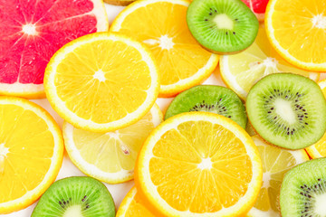 Fototapeta na wymiar citrus slices - kiwi, oranges and grapefruits on white background. Fruits backdrop