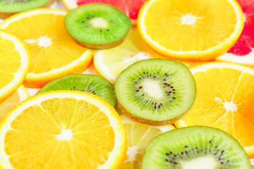 Naklejka na ściany i meble citrus slices - kiwi, oranges and grapefruits on white background. Fruits backdrop