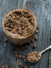 homemade coffee scrub with sugar and coconut oil in a jar on a wooden dark background