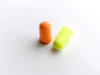 Orange and green ear plugs alignment isolated on white background