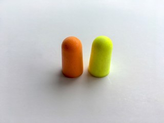 Orange and green ear plugs alignment isolated on white background