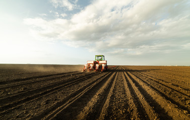 Fototapeta premium Farmer with tractor seeding soy crops at agricultural field