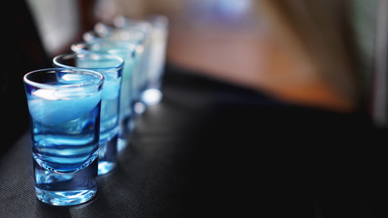 Glasses of vodka with ice. In bar - blurred background