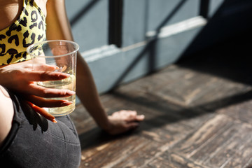  girl with big nails holds a plastic cup in her hand with a transparent liquid, juice, water, the concept of a healthy lifestyle, thirst, environmental protection