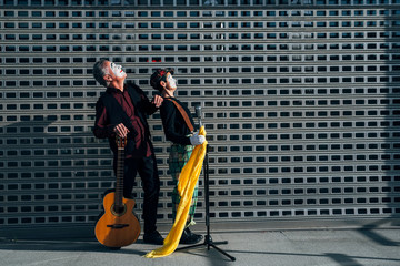 Two mimes on the street singing and playing guitar
