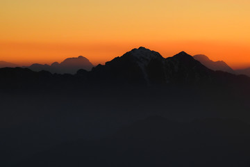 Profili di montagne al tramonto rosso fuoco