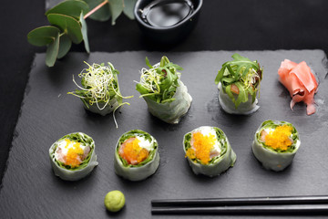 Fototapeta na wymiar Spring sushi, sushi rolls with salmon, rucola, philadelphia cheese.