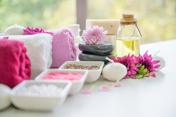 Obraz na płótnie Canvas Aroma therapy oils placed next to a white towel and flower