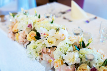 Udekorowane kwiatami i ozdobami stoły na uroczystości rodzinne takie jak wesela - obrazy, fototapety, plakaty